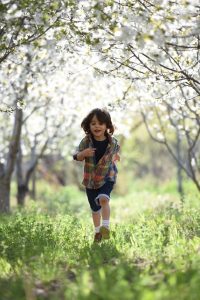 elementary student running in forest